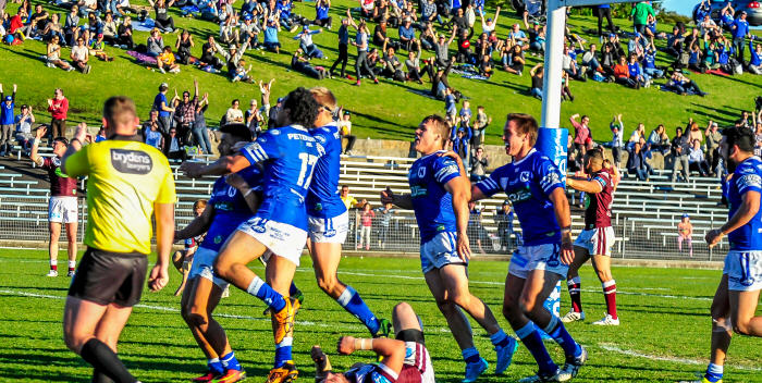 Newtown half-back Fa’amanu Brown is mobbed by his Jets team-mates after scoring the try in the game’s 78th minute that enabled the Jets to draw level with Manly-Warringah at 38-all. Brown then converted his own try for Newtown to win 40-38, after the Jets had trailed 38-12 at the 62nd minute mark. Photo: Gary Sutherland Photography

