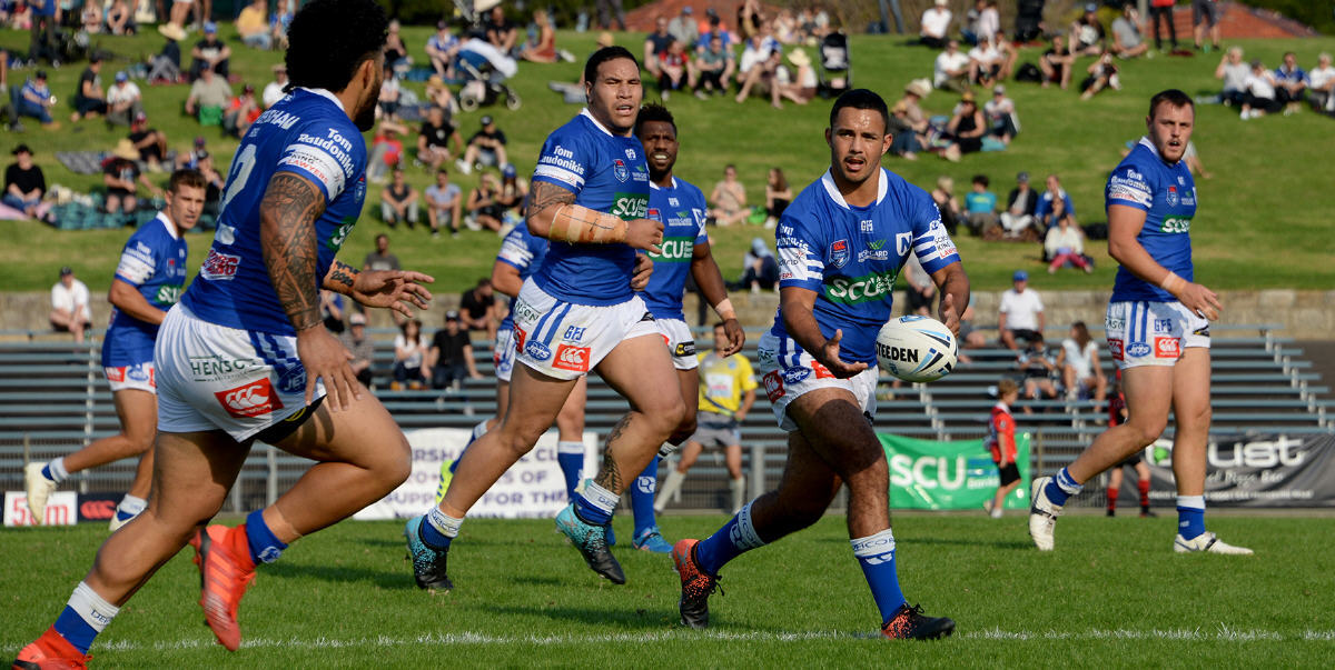 Newtown Jets halfback and ace goal-kicker Braydon Trindall looks to pass to backrower Siosifa Talakai in last Saturday’s nerve-wracking 32-30 win against North Sydney at Henson Park. Photo: Michael Magee Photography.
