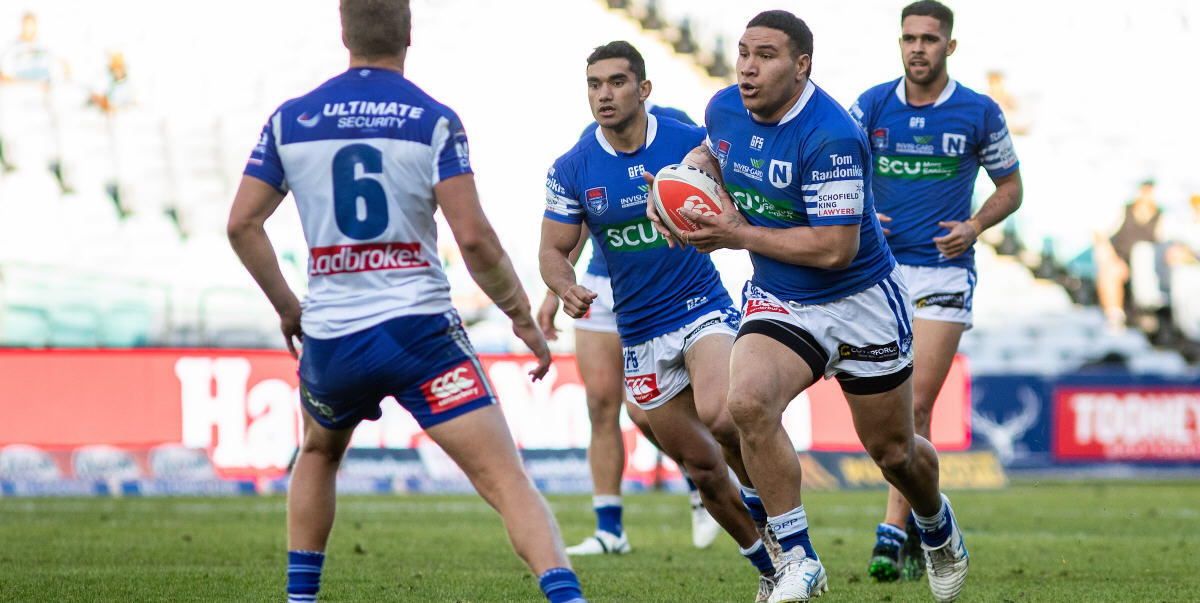 Newtown front-rower Wes Lolo takes the ball forward against Canterbury-Bankstown at ANZ Stadium last Sunday. Jets team-mates supporting Wes are (from left) Tyla Tamou and Will Kennedy. Photo: Mario Facchini, mafphotography