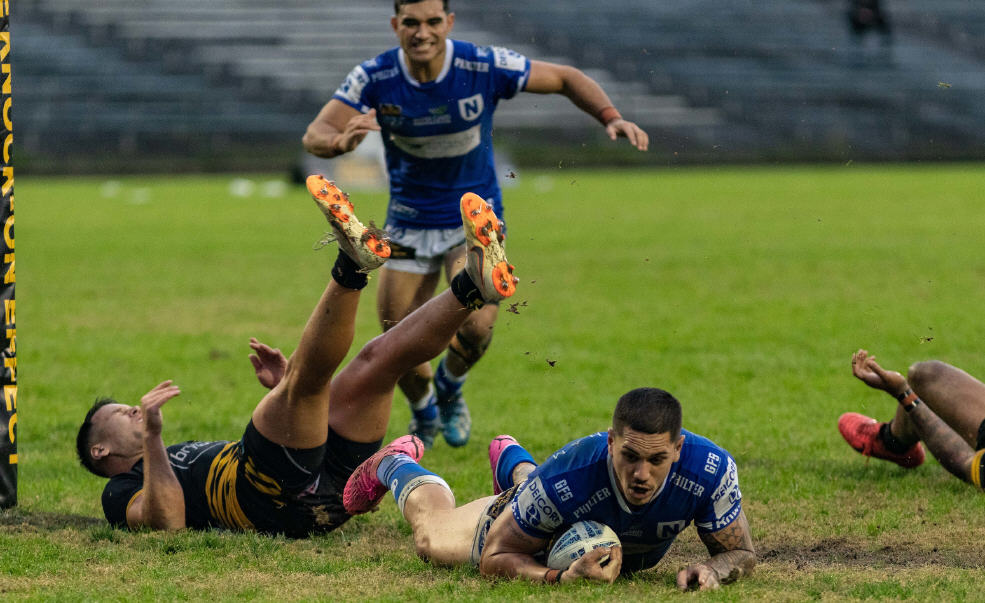 TRY TIME! Jets colossus Myles Taueli crashes over for the icing on the mud-cake, much to the delight of Newtown’s “Mr Fix-it”... Tyla Tamou. Photo: Mario Facchini/mafphotography