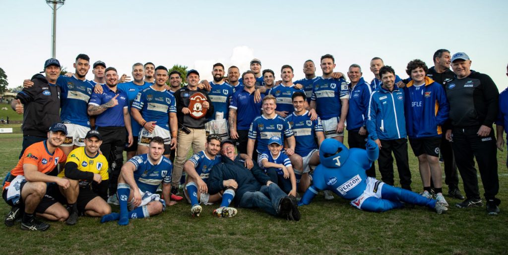The Newtown Jets proudly line up with the 2022 Knock-On Effect NSW Cup Minor Premiership trophy. Photo: Mario Facchini/mafphotography