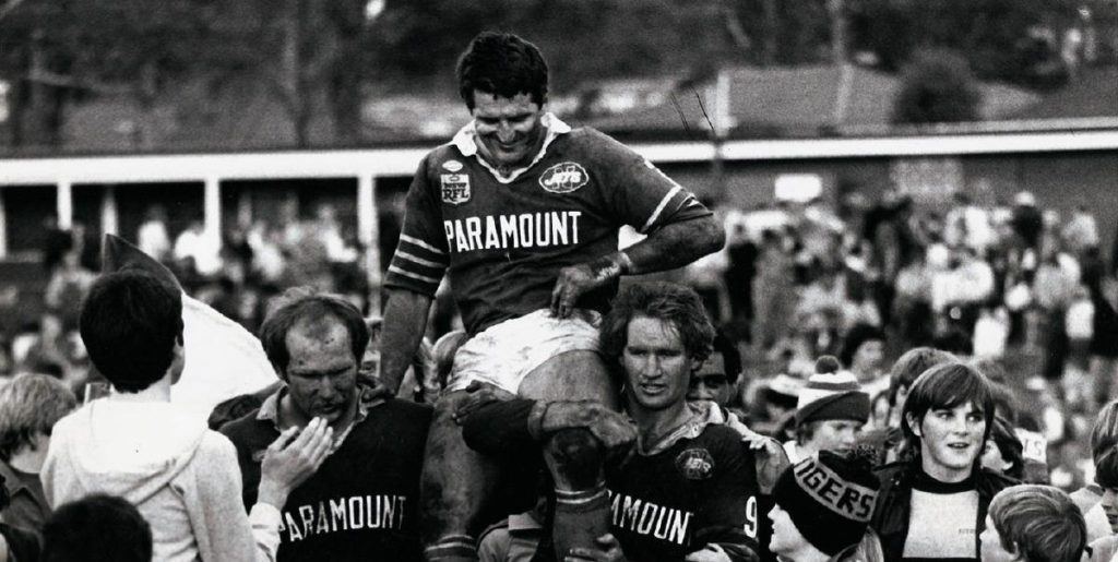 Ken Wilson is chaired off by Geoff Coburn and Mal Graham after the Jets final match in 1983.